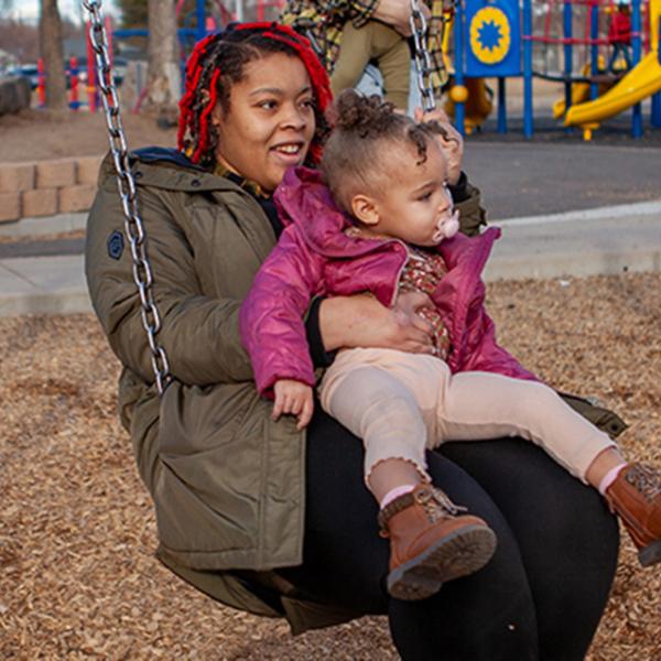 Charlie Guy and daughter on a swingset