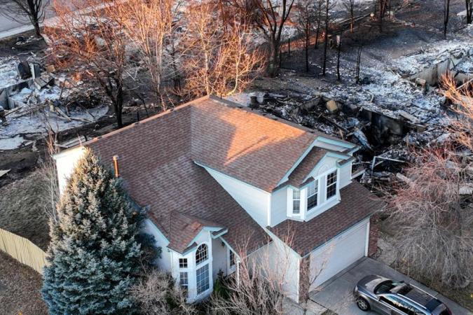 Home remains untouched after fire destroys homes on either side.