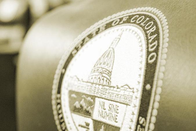Closeup of the State of Colorado seal on the headrest of a chair in the House of Representatives