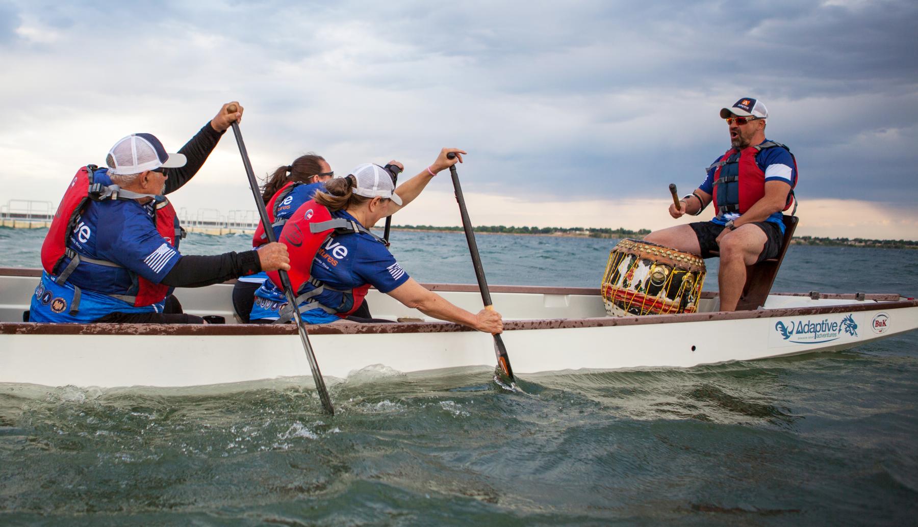 Marc Hoffmeister, right, keeps the beat at the front of the Team Blue dragon boat. Marc turned a combat injury into an opportunity to help other people with disabilities participate in physical activities.