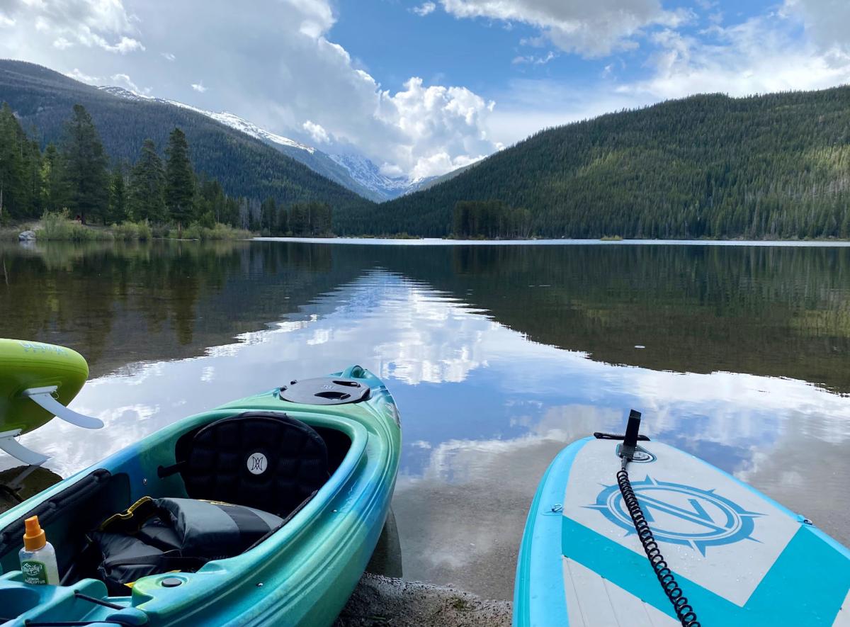 Empty kayaks at beached at the edge of a mountain lake