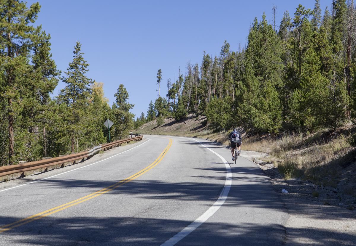 Cyclist riding up a mountain road near the pass