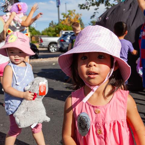 Young girl in a pink tank top and bucket hat at a farmer's market